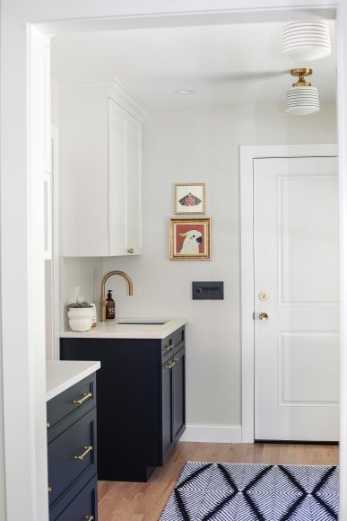 The new mudroom connects
to the garage — which solved the kitchen entryway problem
the Kleins had. The lower cabinets are painted in Sherwin- Williams’ Inkwell. Sleek Schoolhouse Electric lights add flair to the space.