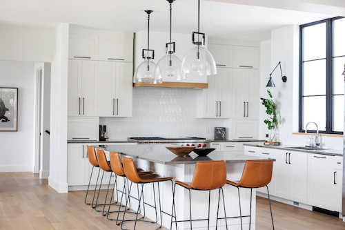  LIGHT AND FRESH
Looking bright and airy, the Instagram- worthy kitchen acts as a focal point in this home. Since Anne and Tom love
to cook, they desired a kitchen where their entire family could congregate while whipping up meals together.
