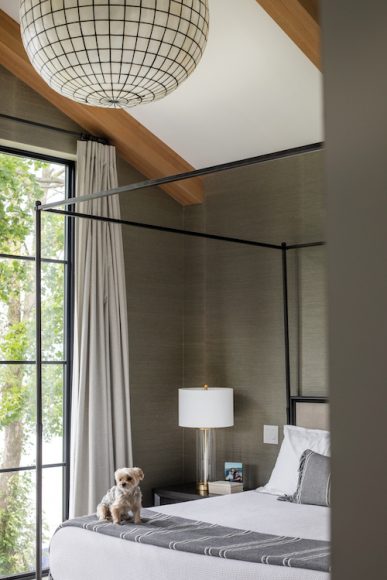 Featuring wood beams and a contemporary light fixture, Anne had a clear vision for the primary bedroom from the beginning. The 10-foot-tall windows take advantage of the view, which centers on the Capitol.