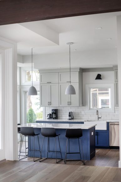 The bright, airy kitchen, which looks out onto the lake, is one of the family’s favorite spots. The custom maple cabinetry was handcrafted by Schmucker Cabinets, an Amish business, with the island and lower cabinets painted in Benjamin Moore’s Hale Navy — a pleasing accent to the neutral upper cabinetry and weathered white subway tile. “I really like the ceramic lights over the island,” Duncan says. “They add a lot of texture.”