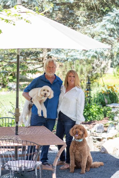 Mary and Jim Baliker pose with their dogs, Kona and Juneau. The dogs love the garden too — “They just sit and enjoy it,” says Mary.