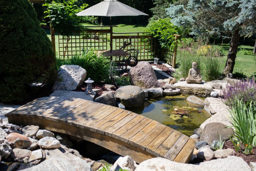 The family can enjoy their garden and dine on their outdoor table. A mini waterfall gurgles in the pond (one of three ponds in the garden) and has a bridge over it.