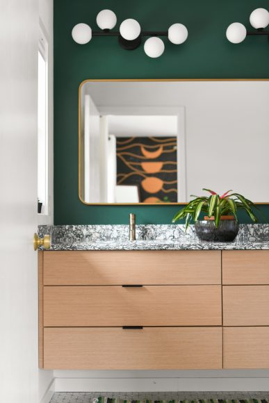 The home’s primary bathroom features a floating vanity, crafted from reconstituted natural oak. The room’s simple, clean lines evoke a sense of calm.