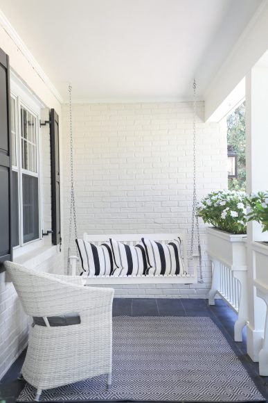 The home’s red-brick façade was painted white, with blue stone pavers forming the porch floor.