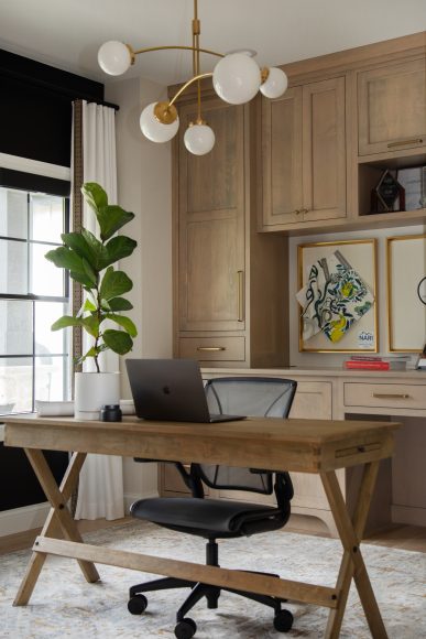 Figaro’s office features custom-built Amish cabinetry and an eye-catching globe chandelier from Visual Comfort.