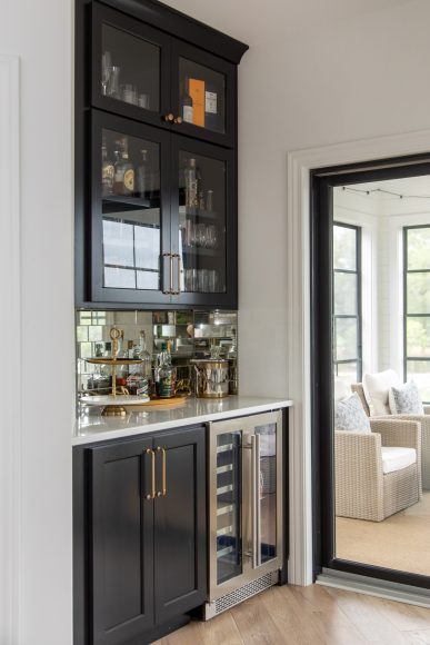 American Design Concepts’ draftsman created an alcove between the walk-in pantry and screened porch, which the Figaros turned into a buffet/bar. The ensemble, which contains a beverage fridge, is painted Sherwin-Williams’ Tricorn Black and accented by Virginia Tile’s Obsidian Antique Silver Mirror Tile. “I wanted to glam it up by adding the antiqued mirror backsplash, which reflects the undercabinet light,” Figaro says.