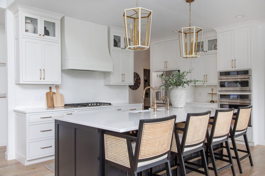 The kitchen features a spacious island, allowing the family to cook and bake together. Brushed gold fixures add a touch of shine to the room. The textured chairs encourage anyone to take a seat at the island.