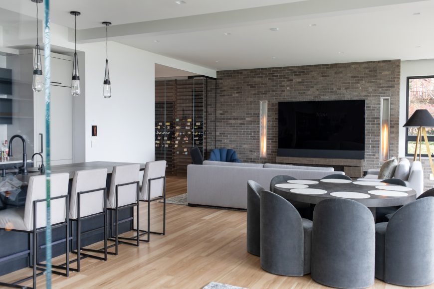 The lower level has a kitchen, spacious game table and a glass-encased, refrigerated wine room. While many homeowners hang a television over their fireplace, Cox is not a fan of this practice. Instead, she opted for two vertical fireplaces flanking the television, which lend a cozy ambience to the space.