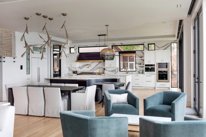 The kitchen features two islands, one of which contains a curved banquette. The striking, contemporary light fixture over the dining table took the electrician one week to hang. Like most of the home’s light fixtures, it came from Madison Lighting.