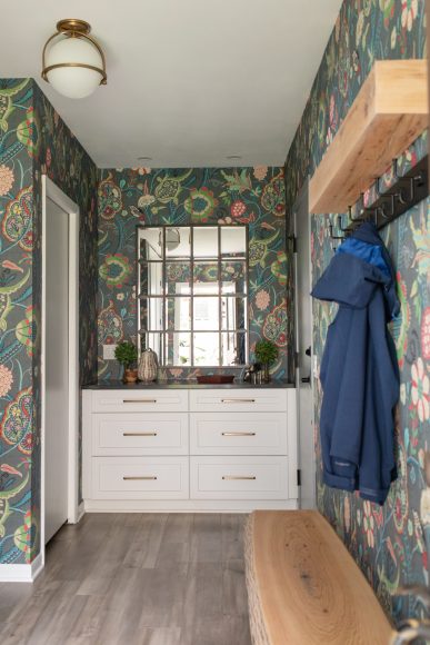 Colorful Thibaut wallpaper in the entry makes an immediate statement. “It’s something fun, unexpected and out of the ordinary,” says Amerell. The white cabinet comes from Minnesota’s Crystal Cabinet Works, and the multi- panel mirror is from Pottery Barn.