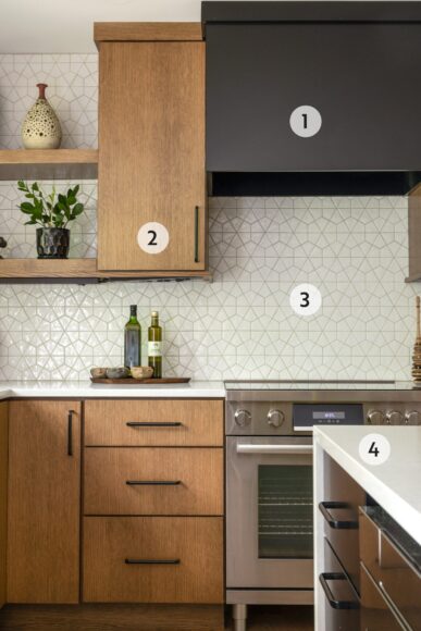 1. Goeser says this “semi-custom” range hood was executed in tandem with Nonn’s. Although it looks like metal, it’s actually wood painted in a satin black shade — and adds a moody pop. 
2. Goeser chose simple slab-front kitchen cabinetry comprised of quarter-sawn oak finished in a cashew stain with modern black hardware to reflect the home’s midcentury aesthetic. 
3. Daltile’s geometric backsplash tile goes all the way up to the ceiling. Goeser explains, “We wanted something that was visually interesting and had a major impact.” 
4. The white quartz island has a waterfall edge and black cabinets underneath. Goeser says the white and black shades serve as a nice contrast to all of the wood in the kitchen.