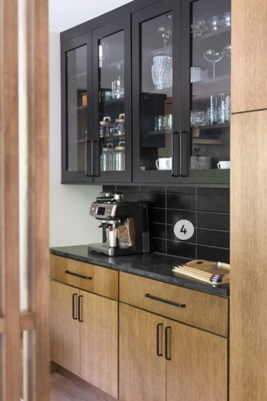 4. The kitchen’s coffee nook (that houses the homeowner’s espresso machine) has beautiful black backsplash tile and cabinetry. Goeser painted the back of the cabinets black to let the homeowner’s glassware shine.