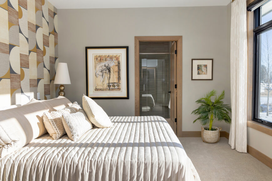 The guest suite’s night table is finished with lacquered grasscloth. Gold is woven in as an accent throughout the home, including in the lamps and furniture hardware in the guest room.