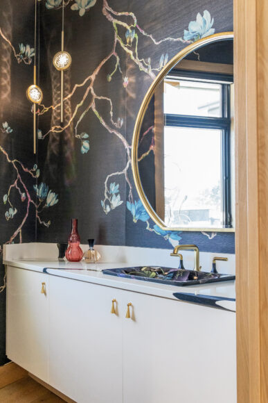 The burnished brass and crystal pendants in the powder room were sourced from Madison Lighting, as were most of the home’s light fixtures.
The powder room wallpaper features flowers and vines that lend the entire space a luxe, opulent look.