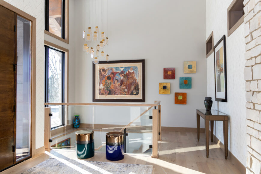 The homeowner requested a glass-paneled stairway to create a more open, airy look — it also allows easier viewing of her artwork.