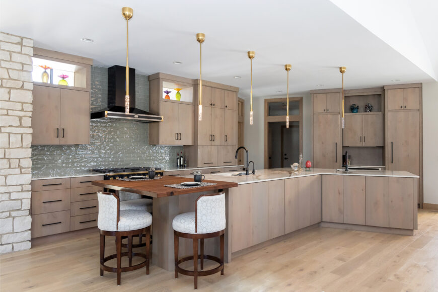 The kitchen’s alder cabinetry, which mimics the lighter hues found throughout the home, was crafted by Dybdahl Design Group. A sleek, black La Cornue dual-fuel range and matching hood provide a striking accent, while the walnut tabletop attached to the island, created by Wisconsin Timberworks, adds a warm touch.