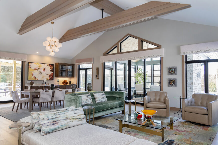 The green mohair sofa is the great room’s signature piece. To tie the room together, pops of green can be found in the watercolor-patterned rug and throw pillows.