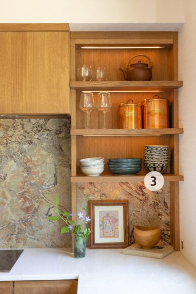 3. The custom oak floating shelves that bookend each side of the range has integrated lighting that illuminates curated displays of glassware, copper canisters and stoneware pottery that Ryan creates in her home studio. Ryan’s thoughtful styling completes the vignette, with vintage artwork and objects collected during her travels.