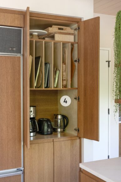 4. “The coffee bar and appliance garage are cleverly concealed beside the refrigerator, blending seamlessly with the surrounding cabinetry,” explains Schultz. The kitchen’s bespoke design allows for customization in the cabinetry, including dedicated slots for sheet pans and cutting boards.