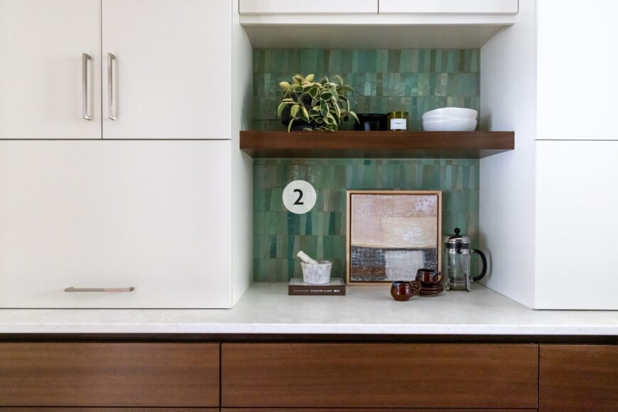 2. In the pantry, trapezoid-shaped zellige tile adds a kick of color to the backsplash. The upper cabinets are painted white, while the base cabinets are walnut to match the kitchen. The pantry has a sink (not shown) to make food prep easier and out of view of guests.