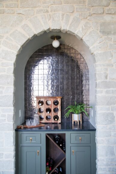 The sunroom’s dry bar features smoky, iridescent glazed tile; a soapstone countertop; and cabinets painted in Sherwin- Williams’ Cast Iron.