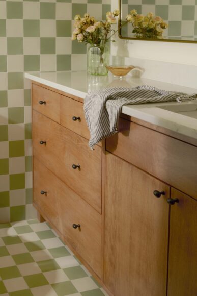 This eye-catching bathroom has a custom vanity and concrete green and white Zia tiles. The tiles are used on the floor and the walls, and the last two feet to the ceiling has vertical white tiles to pull the room together.