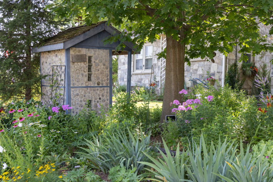 “A neighbor’s grandson made [this garden shed] out of cut logs,” says Aaroen of the rustic structure on the museum's grounds. “It's a nice backdrop for the plants.”