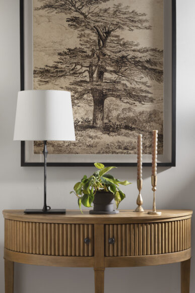 This vignette includes an assortment of found objects curated by Stone House Collective, including the clay pot and asymmetric candlestick holders.