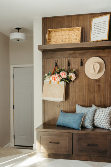 What was once a railing was expertly rebuilt into a handy drop zone with hooks and storage for the family. The walnut paneling matches the range hood for a cohesive look.