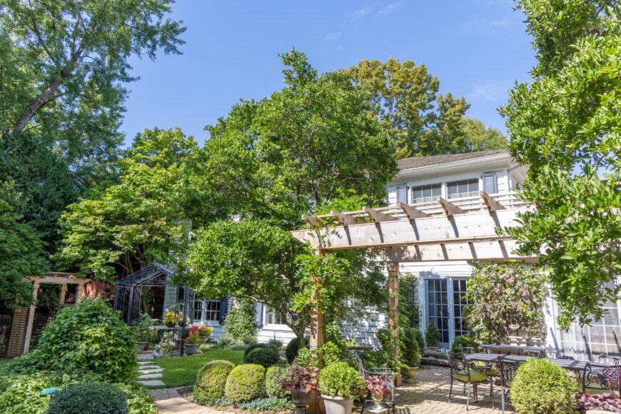 The pergola serves as a striking focal point in the landscape, creating a defined outdoor living space while providing filtered shade and year-round visual interest. Enhanced with climbing vines and surrounding greenery, the structure adds both character and comfort, transforming the patio into an inviting extension of the home.
