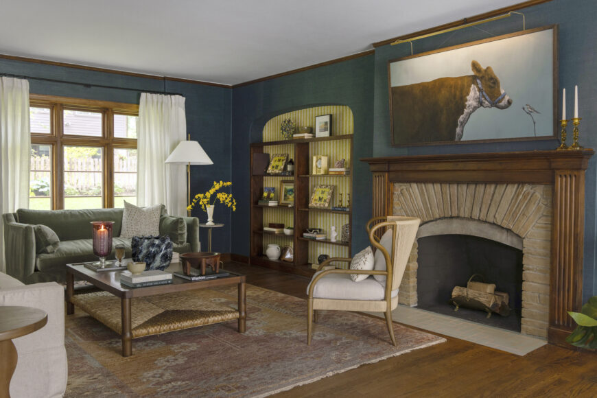 The cow painting that hangs above the fireplace is by Luke Stretar, an Ohio artist, and was a birthday present for Amanda from her father- in-law. Payne says this painting replaced a colorful cow painting that the homeowner had before they redecorated. They retained the original mantle and stonework of the fireplace, but replaced the hearth with handmade tile.